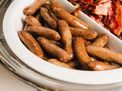 シドニーにあるibis Styles Sydney Centralの食べ物の皿の横にソーセージのボウル