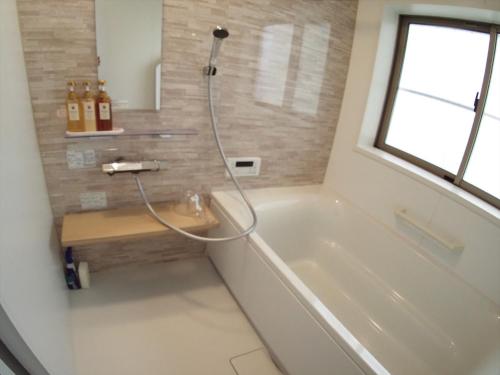 a bathroom with a bath tub and a shower at Maison West Building B - Vacation STAY 18462 in Shimo-nogami