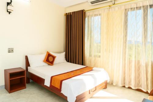 a small bedroom with a bed and a window at Phúc Lộc Hotel Ninh Bình in Ninh Binh