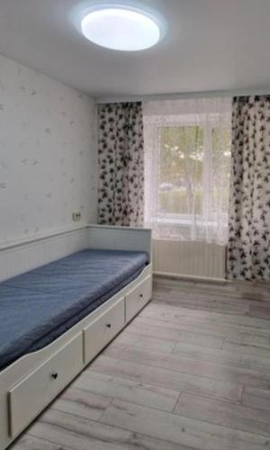 a bed in a room with a large window at Pas Dianą 1 aukštas in Jurbarkas