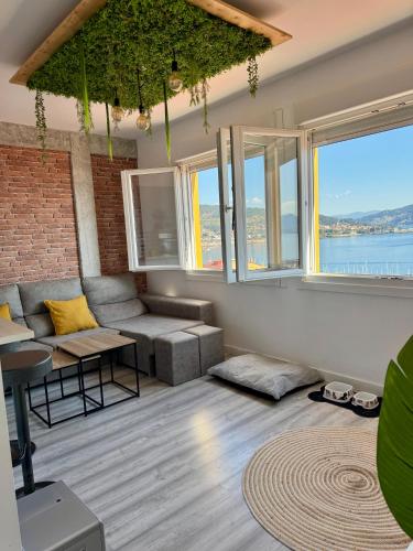 a living room with a couch and some windows at El nido de la gaviota in Moaña