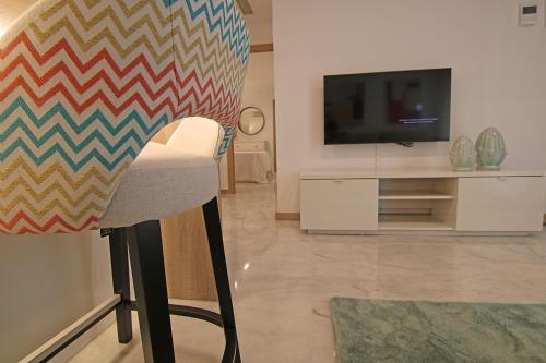 a living room with a chair and a television at Exotik City Apartments 5 in Dos Hermanas
