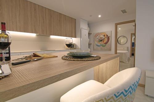 a kitchen with a counter with a glass of wine at Exotik City Apartments 5 in Dos Hermanas