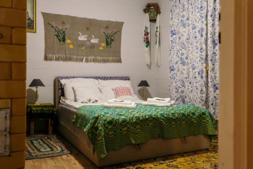 a bedroom with a bed with a green blanket at Dom na wsi u Kasi HAJNÓWKA BIAŁOWIEŻA NA WYŁĄCZNOŚĆ in Stare Berezowo