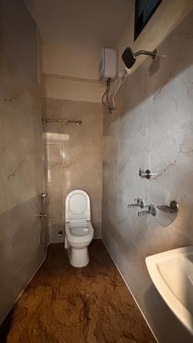 a bathroom with a toilet and a sink at Nila Inn Thampanoor in Trivandrum