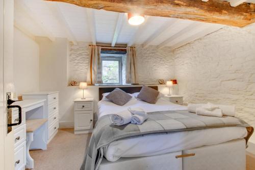 a bedroom with a large white bed in a room at Bovey Cottage in Broadhempston