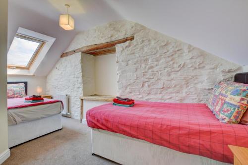 Un dormitorio con dos camas y una pared de piedra. en Brynheulwen, en Llanilar