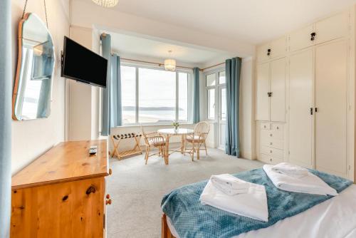 a bedroom with a bed and a dining room with a table at Francis Cottage in Woolacombe