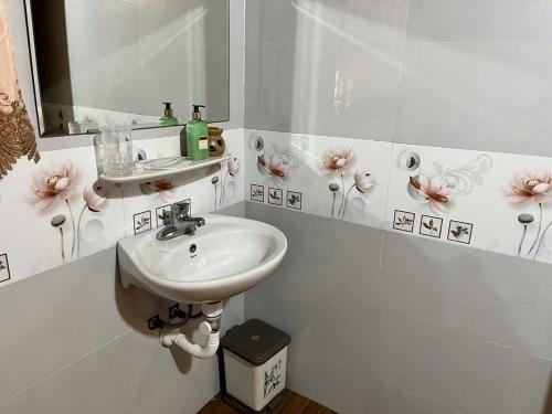 ein weißes Badezimmer mit Waschbecken und Spiegel in der Unterkunft Na Tuệ An-Homestay 81 Võ Văn Kiệt in Tuyên Quang