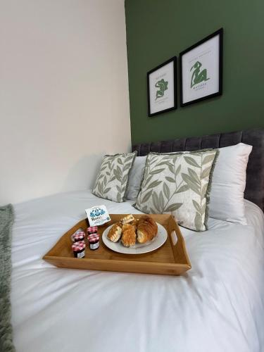 a tray with a plate of food on a bed at Modern & Spacious, 4BR 4Bath, Parking, Sleeps 8 in Coventry