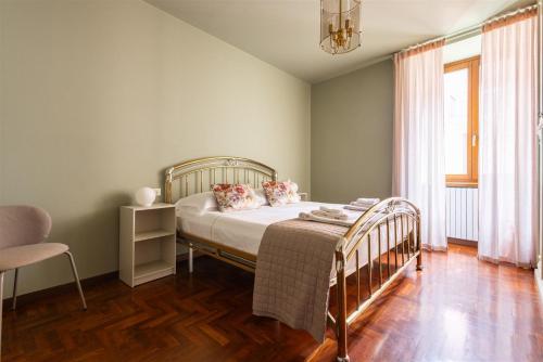 een slaapkamer met een bed en een stoel bij IseoLakeRental - Delfina in Pisogne