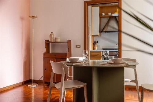 een eetkamer met een tafel en stoelen en een keuken bij IseoLakeRental - Delfina in Pisogne