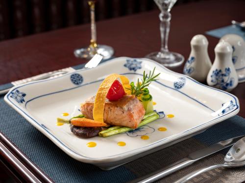 下龙湾Halong L'amour Cruise的桌上有一盘有肉和蔬菜的食物