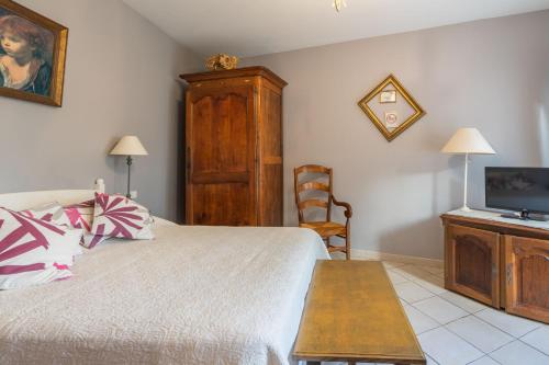 a bedroom with a bed and a flat screen tv at Au Paradis Des Hotes - Chambre Ile in Fouras