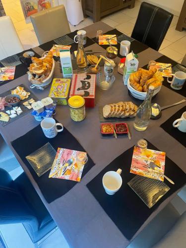 a table with a bunch of food on it at Chambres dans maison avec piscine toboggan aquatique et spa in Saint-Mars-la-Brière