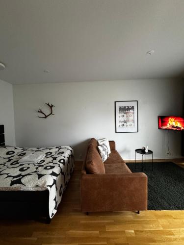 a living room with a bed and a couch at 2 hengen unikkosuite in Rovaniemi