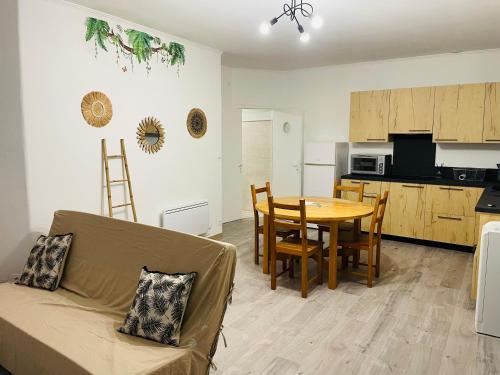 ein Wohnzimmer und eine Küche mit einer Couch und einem Tisch in der Unterkunft Appartement fonctionnel in Malleval