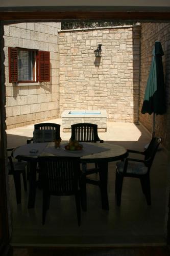 a table with two chairs and an umbrella on a patio at Double Room Puntinak 12255a in Selca