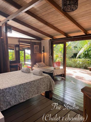 a bedroom with two beds and a wooden floor at My Mountain Home - Le Studio in Taravao