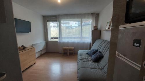 ein Wohnzimmer mit einer Couch und einem Fenster in der Unterkunft Studio avec Balcon - La Godille - 4 personnes in Les Adrets