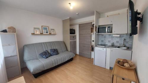 ein Wohnzimmer mit Sofa und eine Küche in der Unterkunft Studio avec Balcon - La Godille - 4 personnes in Les Adrets