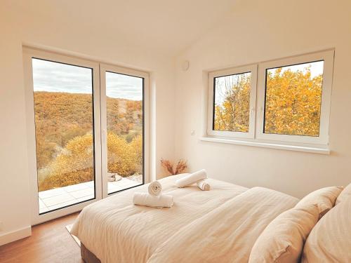 een slaapkamer met een bed en twee ramen bij Eulennest mit Whirlpool und Sauna in Bermel