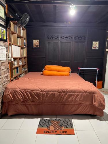 a bed with an orange pillow in a room at Lego Lego Bulubarakka homestay and cafe in Kasijala
