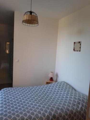 a bedroom with a bed with a blue comforter at Logement indépendant au cœur d'une ferme in Blandin