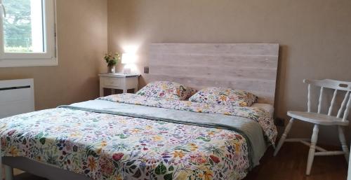 una camera con letto con testiera in legno e sedia di La Maison de Rolie a Plévin