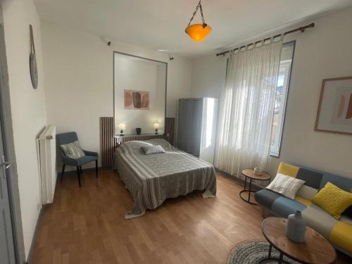 a bedroom with a bed and a couch at Charmant appartement F1 in Fraize