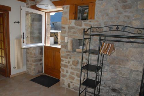 a room with a stone wall with a ladder in it at Gîte du Lieu Piquot in Gréville-Hague