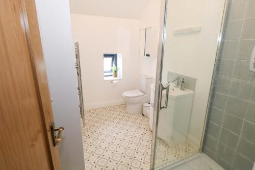 ein Badezimmer mit Toilette und Glasduschtür in der Unterkunft Rose Cottage in Killala