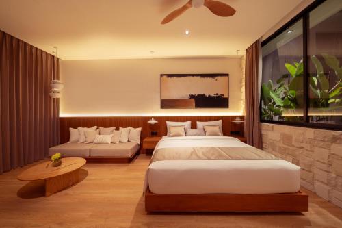 a hotel room with two beds and a couch at Sawo Villa Canggu - Private Brand New 2BR Villa in Canggu