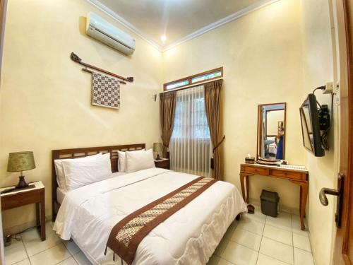 Ένα ή περισσότερα κρεβάτια σε δωμάτιο στο Ndalem Panembahan 12 Guest House