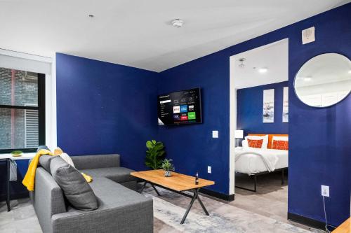 CozySuites Stunning 1BR in Downtown Pitts #03 في بيتسبرغ: غرفة معيشة مع أريكة وغرفة نوم