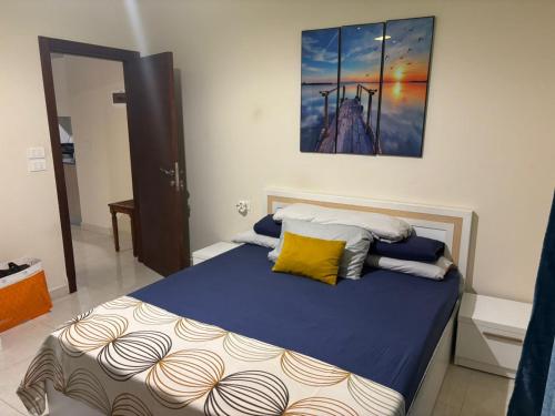 a bedroom with a bed with a painting on the wall at Quiet HOME in Hurghada