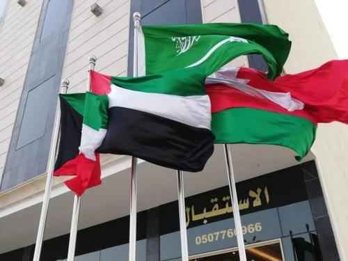 two flags are flying in front of a building at ورد للشقق المخدومة - احد رفيدة in Ahad Rafidah