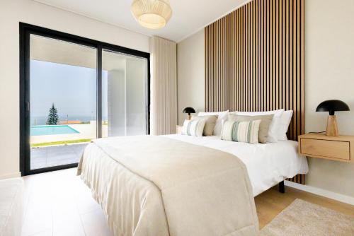 a white bedroom with a large bed and a large window at Vale Furado Sea & Nature - BY SCH - B in Vale Furado
