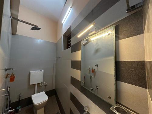 a bathroom with a toilet and a shower at SeaCret by Dormer Stay in Kozhikode