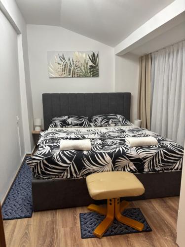 een slaapkamer met een zwart-wit bed en een kruk bij Kuća za odmor Tina in Tounj