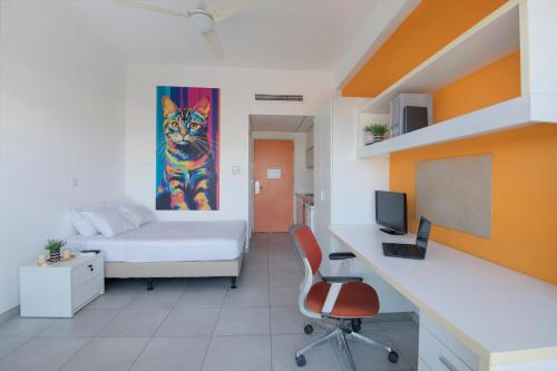a room with a bed and a desk with a computer at UC Hall Residence in Nicosia