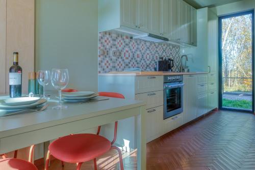 a kitchen with red chairs and a table with wine glasses at Brzozowy Rożnów in Rożnów