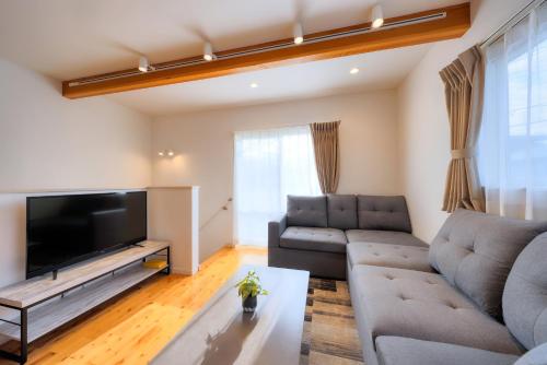 a living room with a couch and a flat screen tv at Villas Waraku in Fujiyoshida