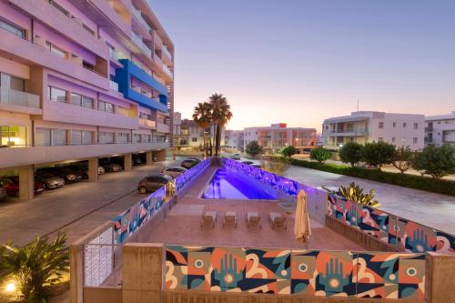 an apartment building with a pool in a parking lot at UC Hall Residence in Nicosia