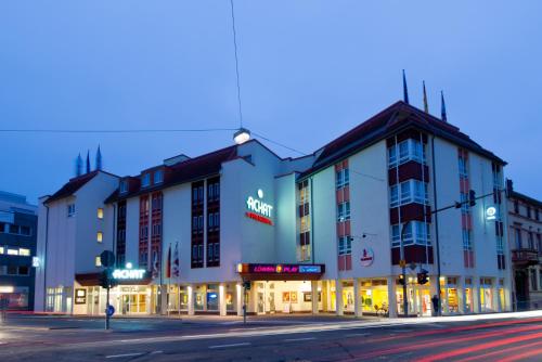 a building on the corner of a street at night at ACHAT Hotel Neustadt an der Weinstraße in Neustadt an der Weinstraße