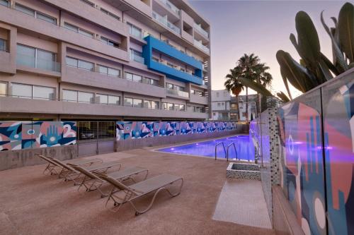 a swimming pool in a building with two benches and a swimming pool at UC Hall Residence in Aglantzia