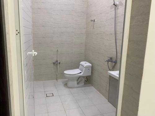 a bathroom with a toilet and a glass shower at شقق المصيف الفندقيه in Hafr Al Baten