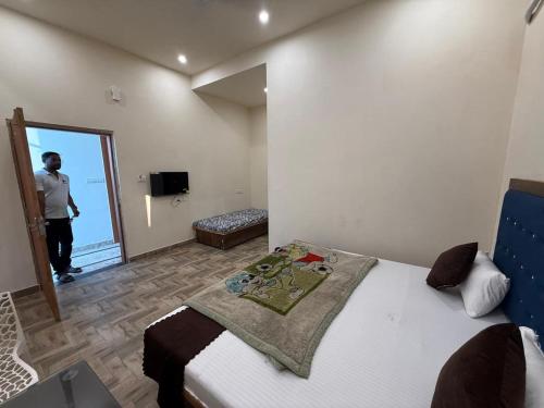 a man taking a picture of a bedroom with a bed at Hotel Pilgriims in Varanasi