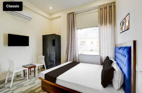 a bedroom with a bed and a desk and a window at Hotel Pilgriims in Varanasi