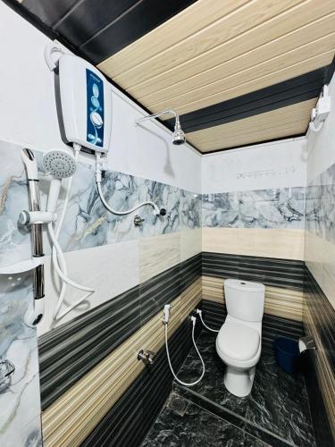 a bathroom with a shower and a toilet in it at Dambulla Tourist Resort in Dambulla